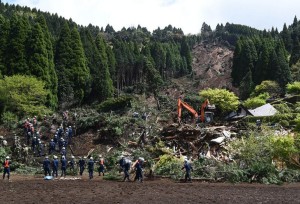 Поиск выживших под оползнем, сошедшем в результате землетрясения в Японии